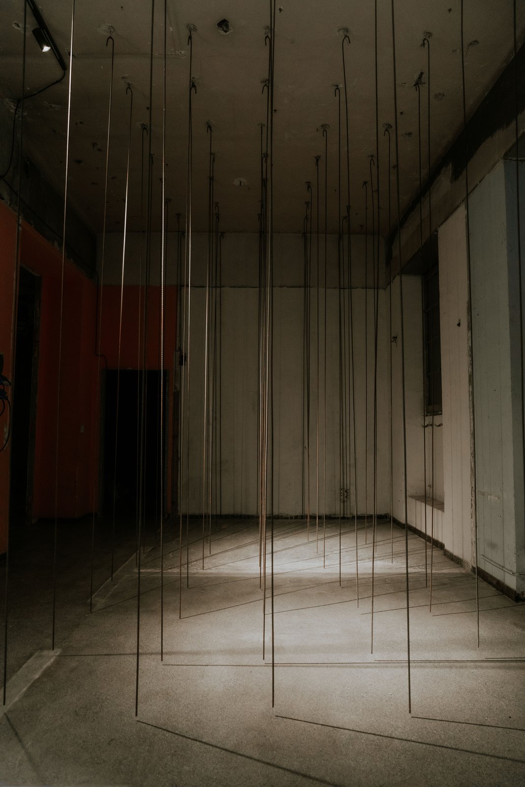 Yes, But… 2026, vertical rods suspended in an empty room